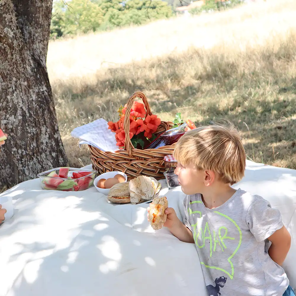 Niño disfruta de un almuerzo al aire libre en la Serra da Estrela.