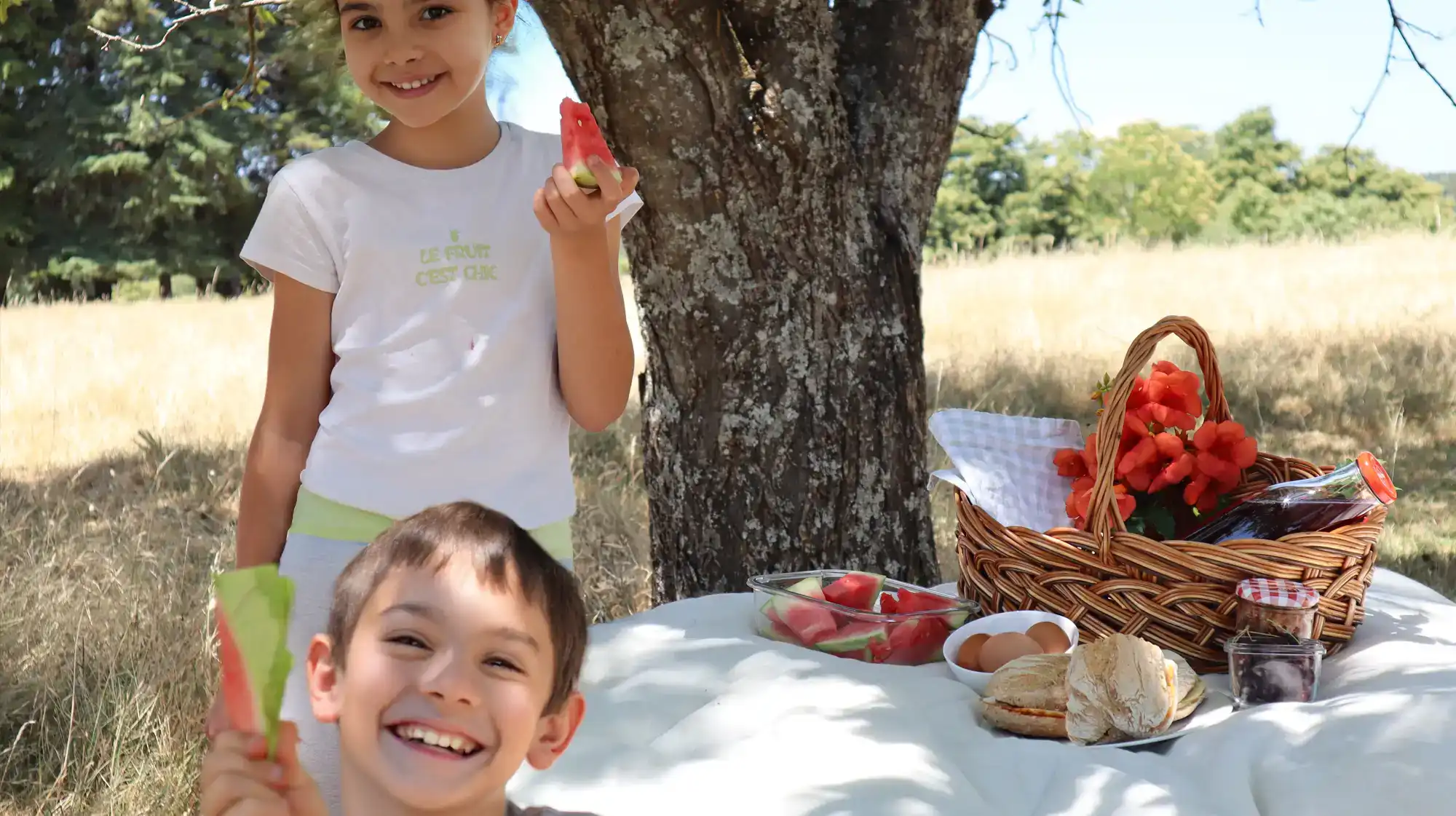 Niños disfrutando de un almuerzo campestre bajo el sol en la Serra da Estrela.