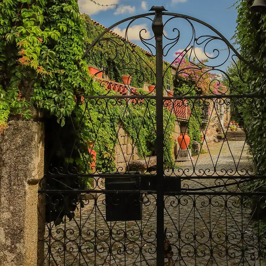Un portal de hierro forjado, enclavado en un entorno rural de ensueño.