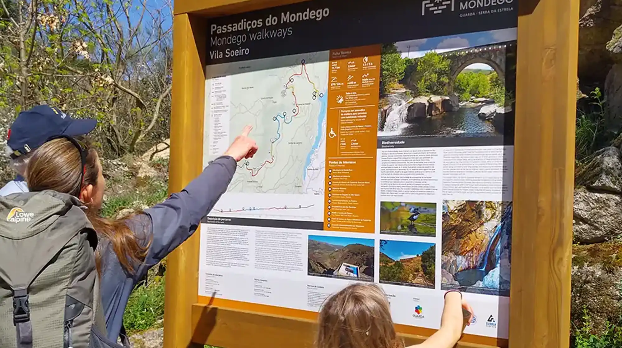 Wooden boardwalk of Passadiços do Mondego with suspension bridge crossing the Mondego River in Serra da Estrela