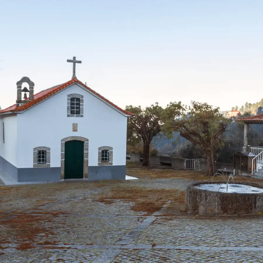 Oude stenen kerkje met fontein, idyllisch gelegen in het groene Serra da Estrela.