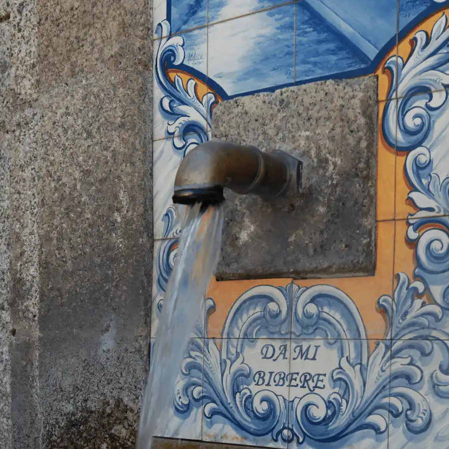 Schilderachtig Portugese fonteinwand met blauw-wit mozaïek en traditionele versiering.