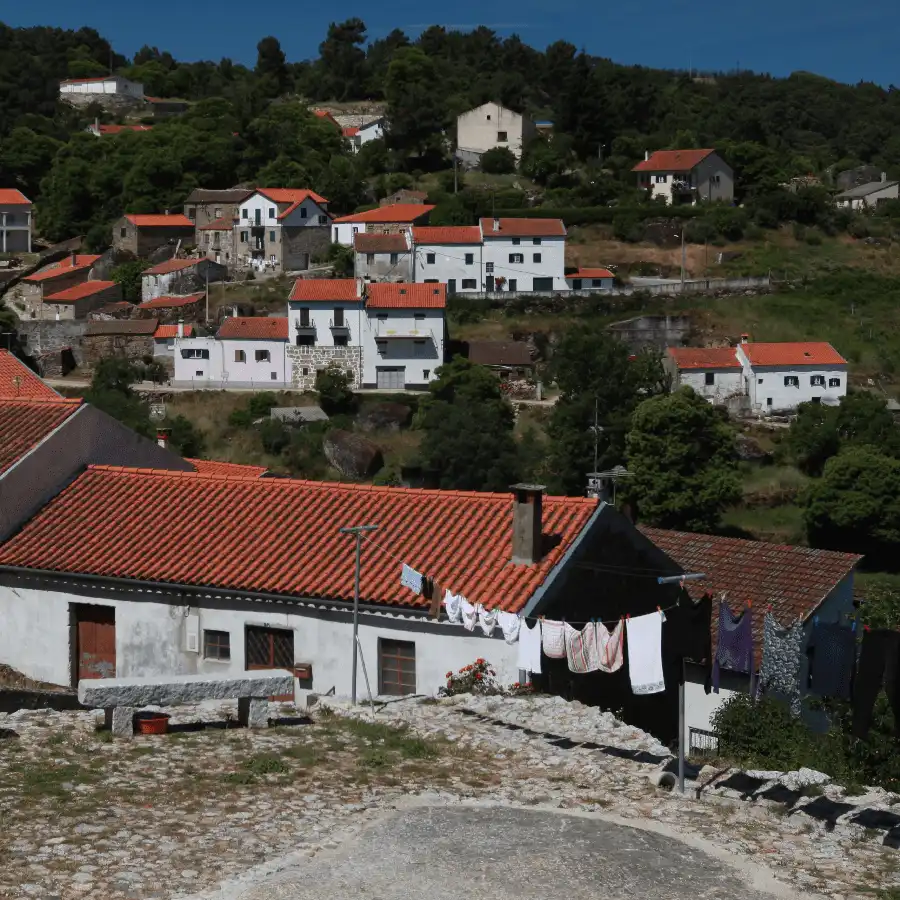 Casas tradicionais de pedra e telha, imersas na paisagem serena da Serra da Estrela.
