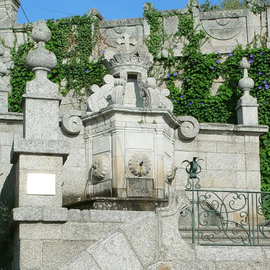 Fonte histórica com detalhes artísticos numa paisagem urbana da Serra da Estrela.