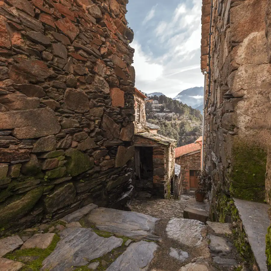 Ruas de xisto antigas na Serra da Estrela, paisagem rural e serena.