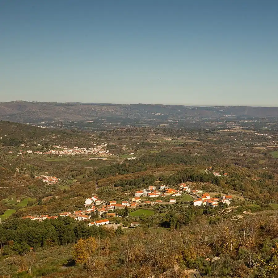 Aldeia serrana acolhedora, paisagem rural tranquila e montanhas imponentes.