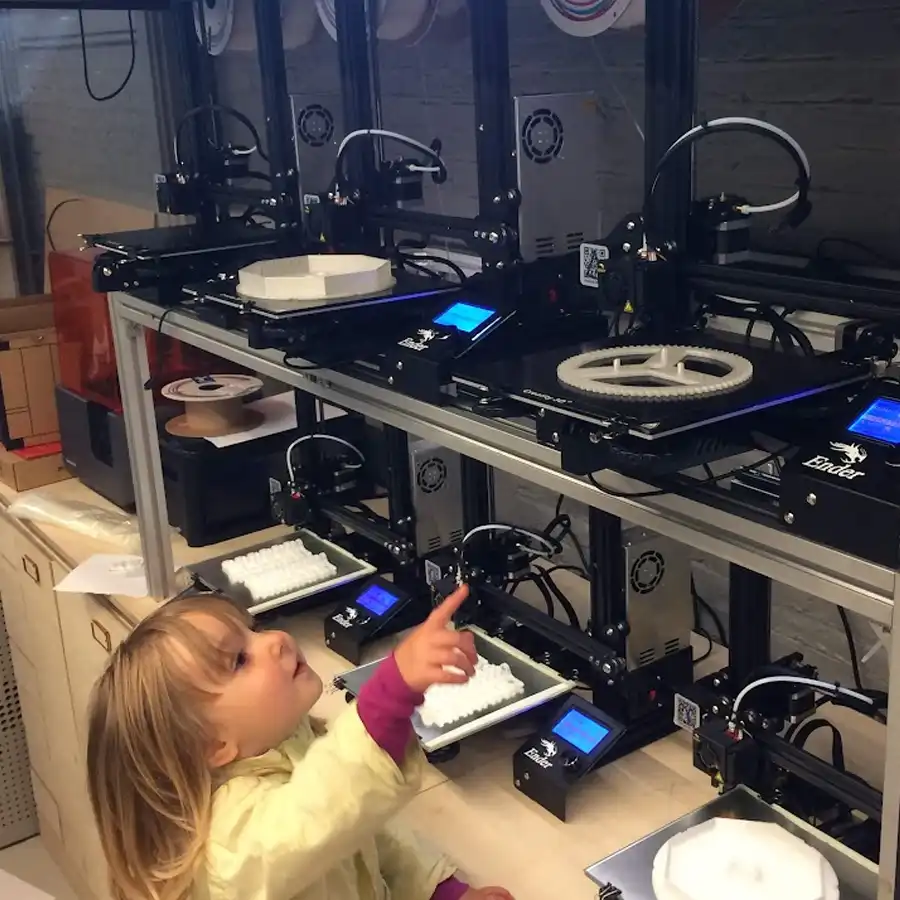 Uma menina curiosa a explorar a tecnologia numa oficina de criação inovadora.